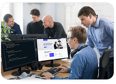 Team of software developers and consultants collaborating on new code, symbolizing our collaborative software development consulting services.